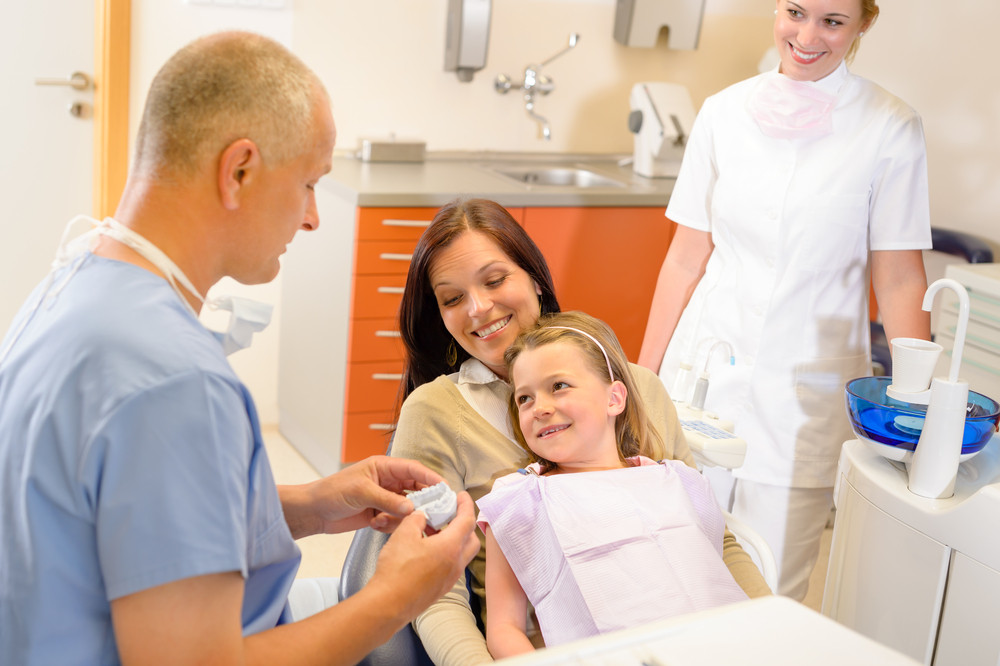 Child visit dentist surgery with mother